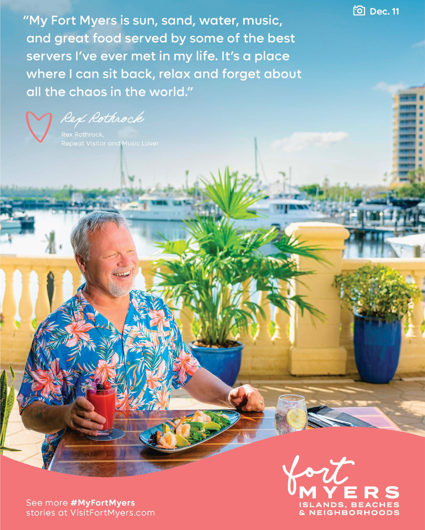 Un hombre disfruta de una comida en una mesa cerca de un puerto deportivo como aparece en un anuncio impreso de la campaña My Fort Myers