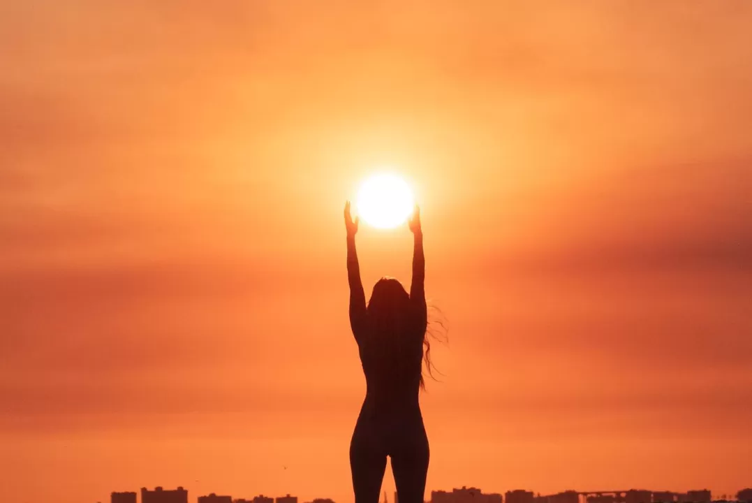 A person standing on a beach at sunset