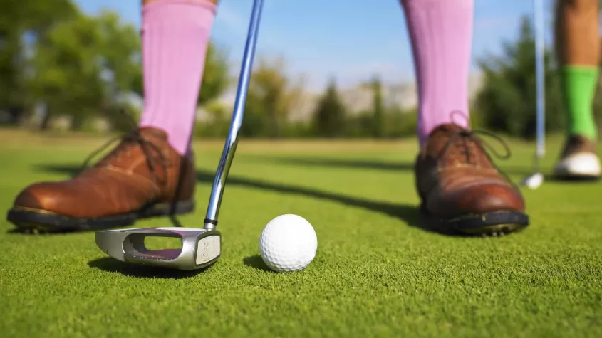 A man is ready to sink his putt.