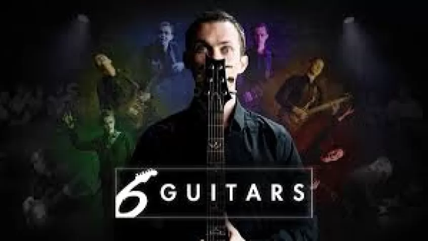 ein Mann vor einem Mikrofon, hinter ihm die Silhouetten von sechs Gitarren in einer Reihe von Farben