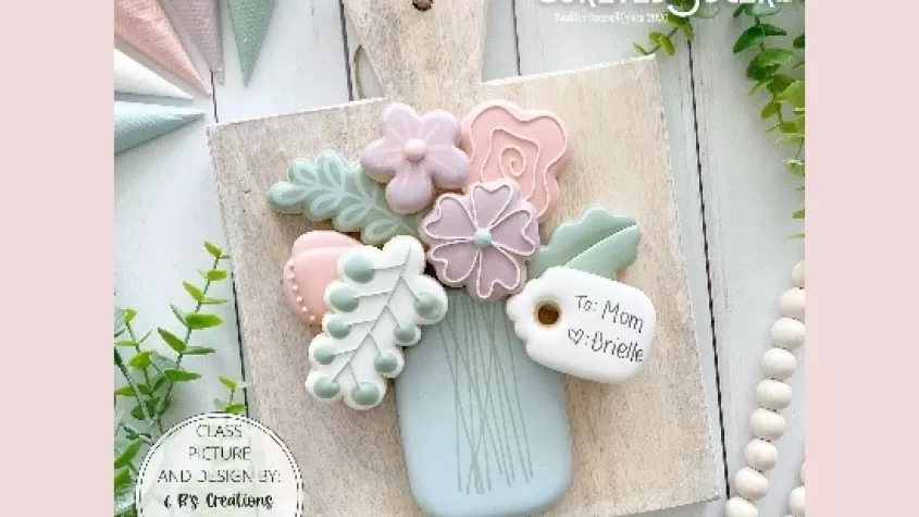 image of a blue vase, flowers and leaves all made out of decorated cookies