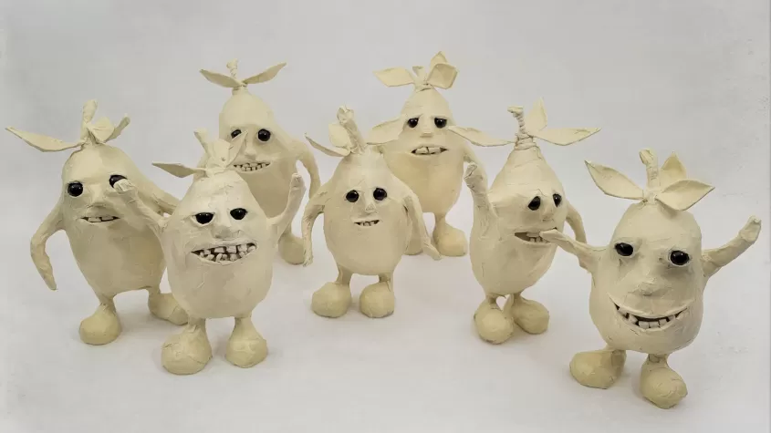 little masking tape figure mangos with leaves, legs, arms, teeth and eyes