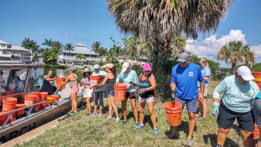 line of people passing buckets of oyster shells