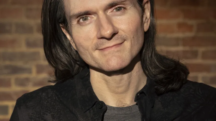 An image of John Mabey, a man with shoulder length hair