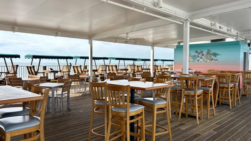 table and chairs outdoor restaurant, colorful back wall