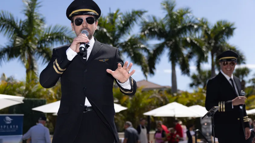 Event photography of a man singing on stage wearing a pilot outfit