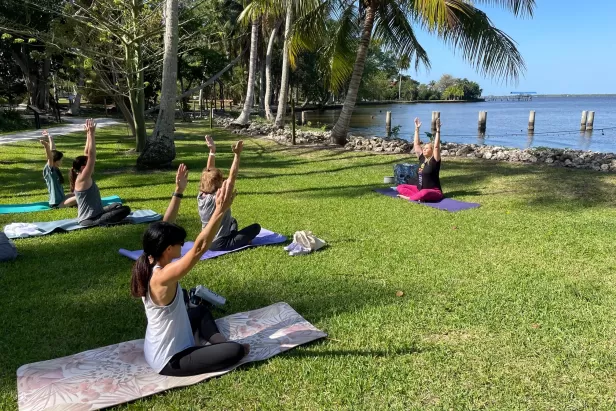 Besucher nehmen an einem Yoga-Kurs am Caloosahatchee River teil.