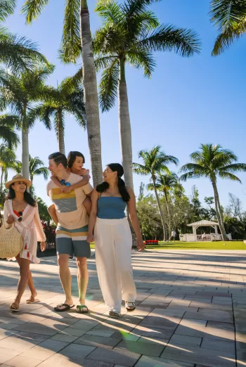 Familie spaziert draußen im Hyatt Regency Coconut Point Resort