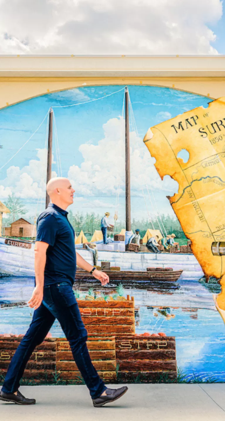 A man walks along a colorful map mural in downtown Bonita Springs