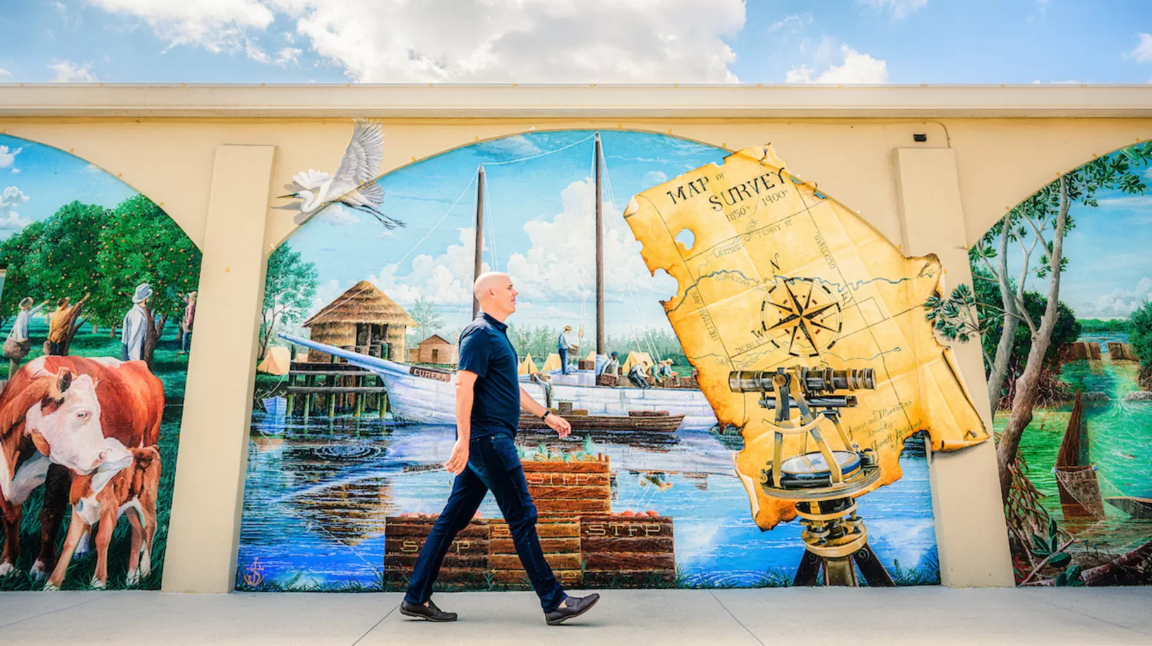 Ein Mann geht an einem farbenfrohen Kartenwandgemälde in der Innenstadt von Bonita Springs entlang