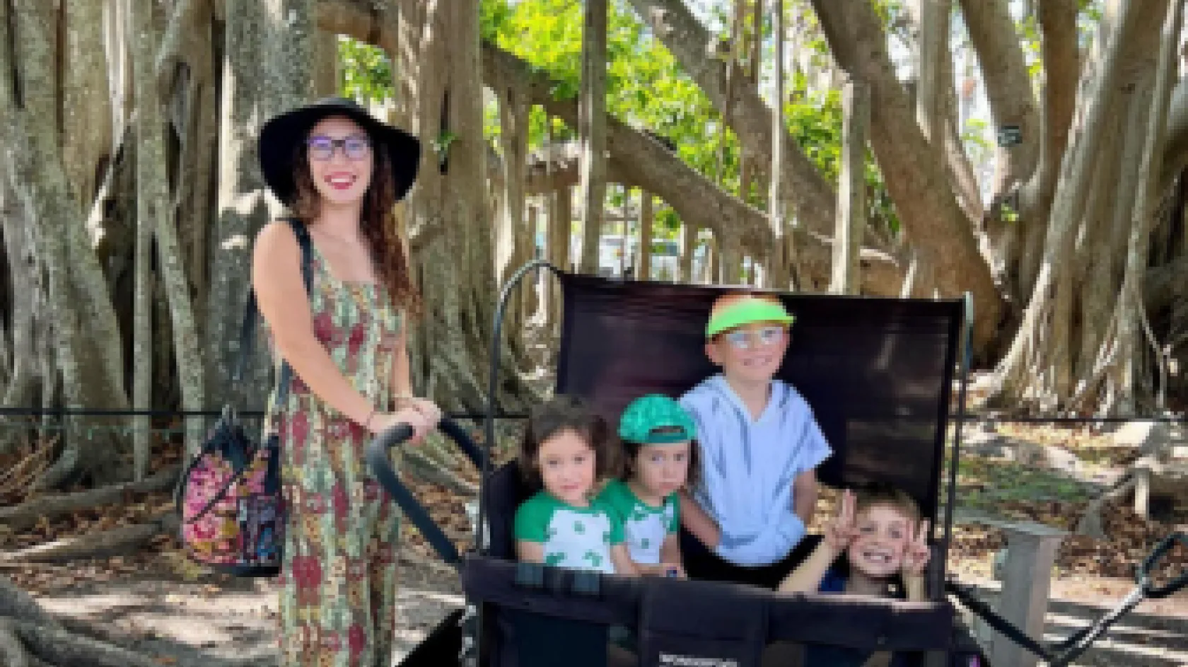 A mom pushes her kids in a wagon through the gardens at Edison and Ford Winter Estates