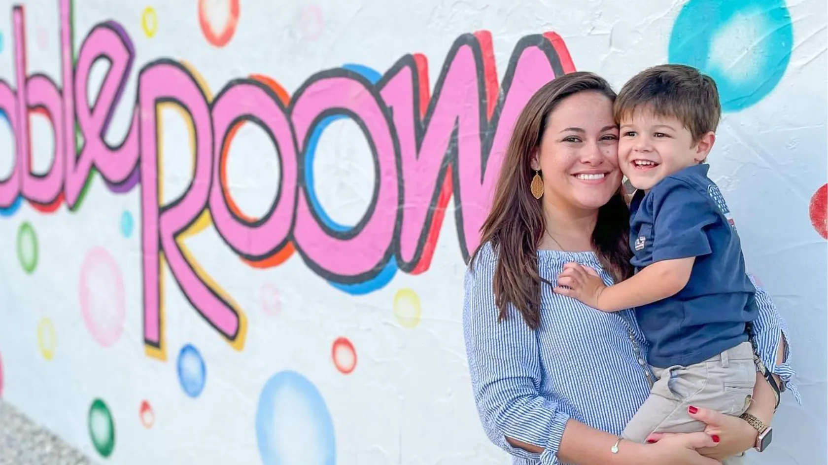 A mom and son pose for the camera at the Bubble Room