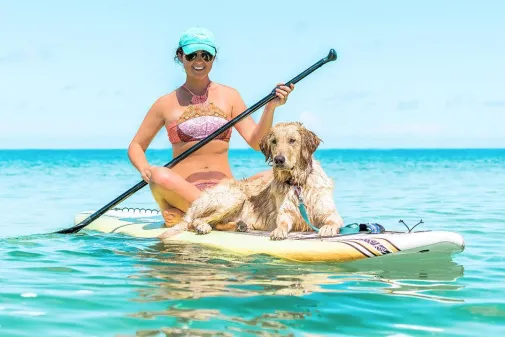 A woman and her dog enjoy paddleboarding