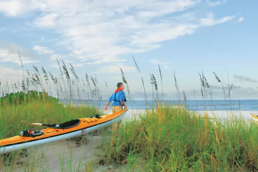 Un couple marchant et tenant un kayak