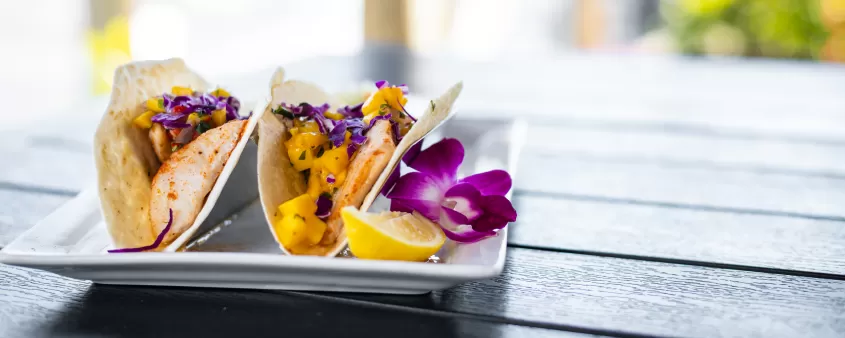 tacos de pescado en un plato en la mesa