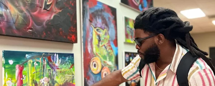 Mann zeigt auf Malerei bei Kunstausstellung