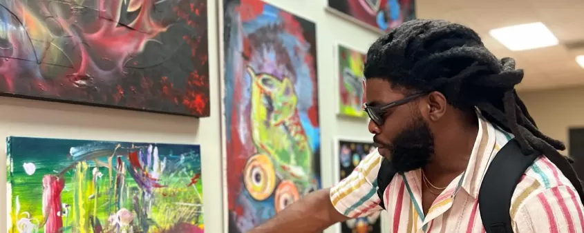 Man pointing at painting at art show