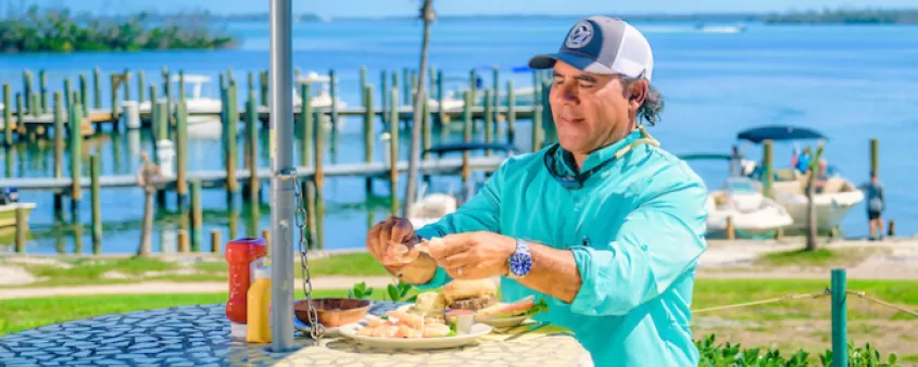 Un hombre disfruta de una comida en una mesa al aire libre en Cabbage Key