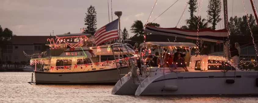Two boats float down a canal in Cape Coral decorated in holiday lights and decor for the annual boat parade.