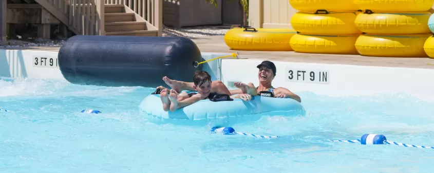 Una mujer y un niño jugando en una piscina.