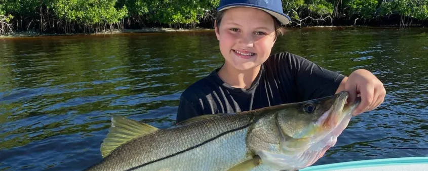 A boy holds up his catch