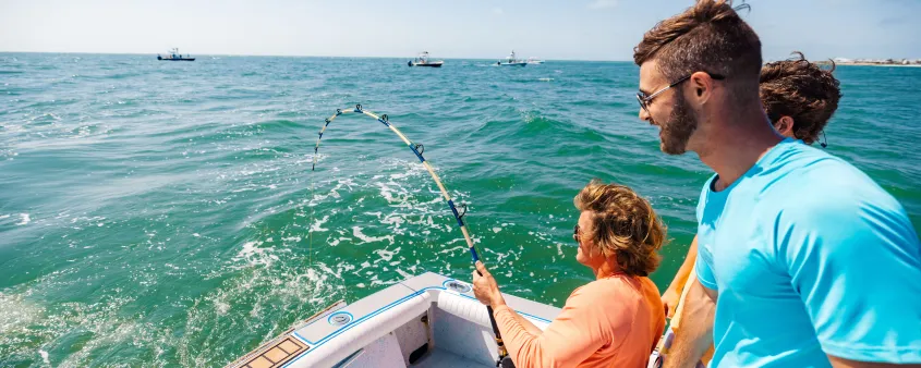 Two anglers fish for tarpon from a boat in the turquoise waters off Boca Grande.