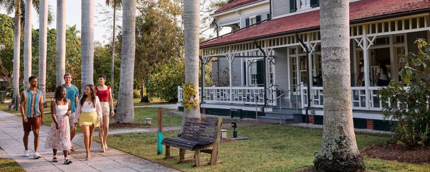Visitors walk beneath palm trees beside the historic Edison and Ford winter homes in Fort Myers.