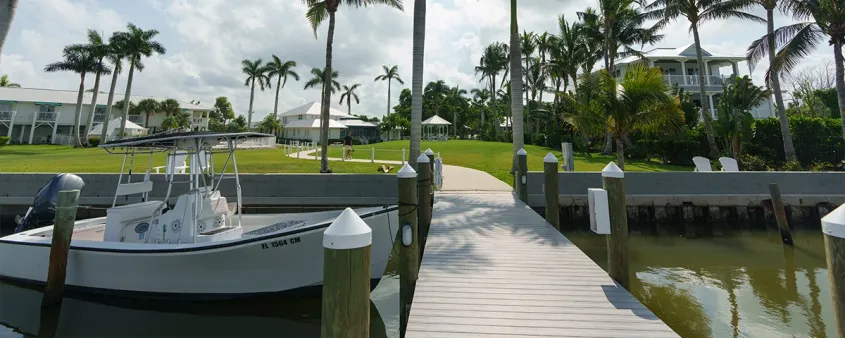 A boat sits at the dock beside the waterfront grounds of Tarpon Lodge on Pine Island.