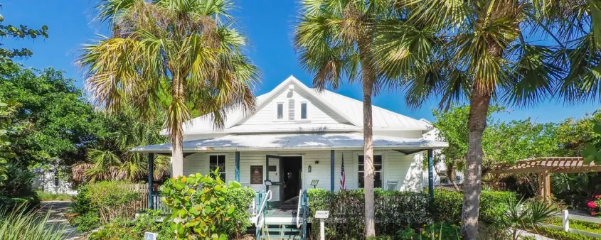 The historic Rutland House at Sanibel Historical Museum and Village is surrounded by palms and native landscaping.