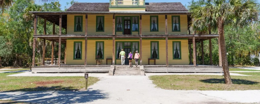 The historic Planetary Court building at Koreshan State Park stands among palm trees in Estero.