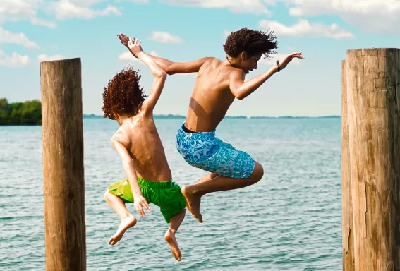 Kinder springen ins Meer