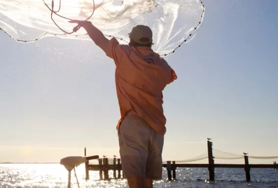 Mann fischt mit einem Netz