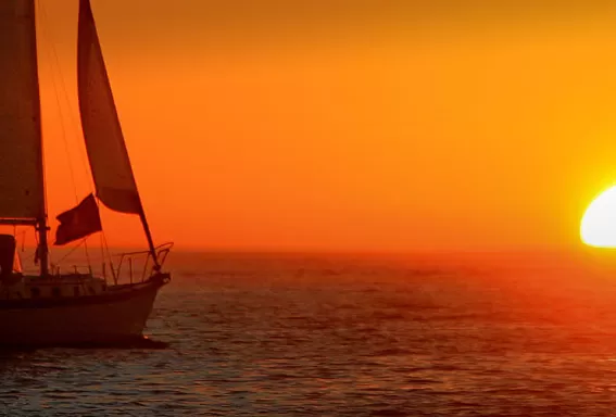 bateau sur l'océan avec un coucher de soleil