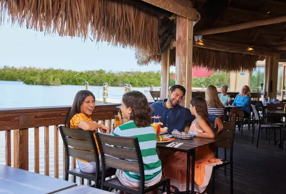 Una familia disfruta de una comida en una terraza al aire libre en Coconut Jacks en Bonita Springs