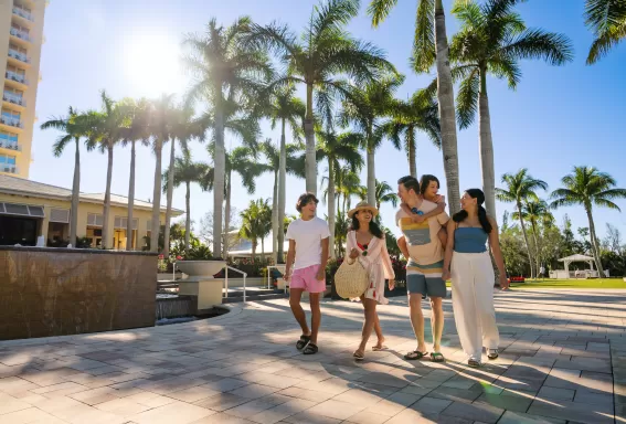 Familie spaziert draußen im Hyatt Regency Coconut Point Resort