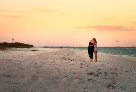 Zwei Menschen umarmen sich bei Sonnenuntergang am Strand