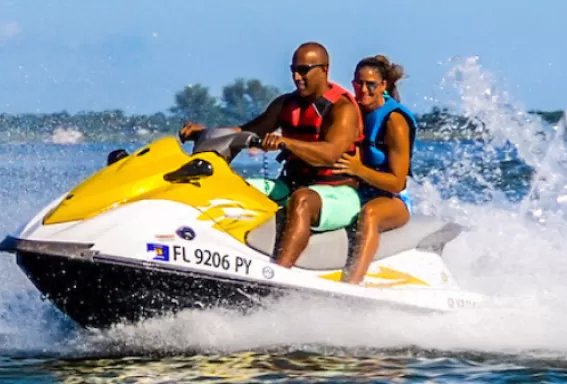 A couple zips across the water on a wave runner