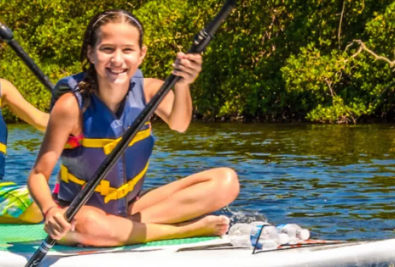 A brother and sister enjoy paddleboarding