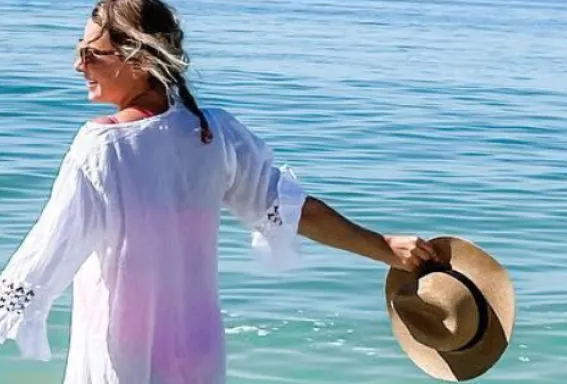 A woman basks in the sunshine on a sunny beach