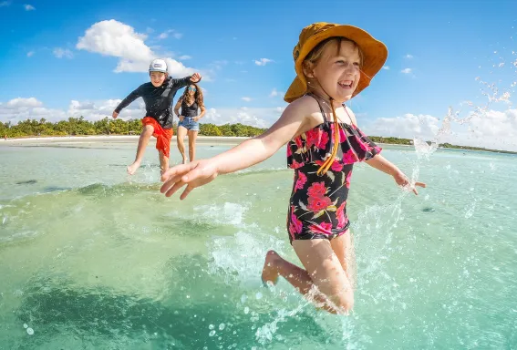 Children splash in shallow Gulf water.