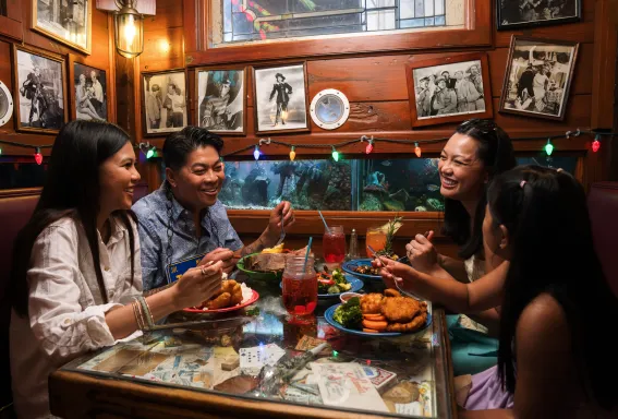 A family shares a meal at The Bubble Room on Captiva Island surrounded by colorful lights and vintage photos.