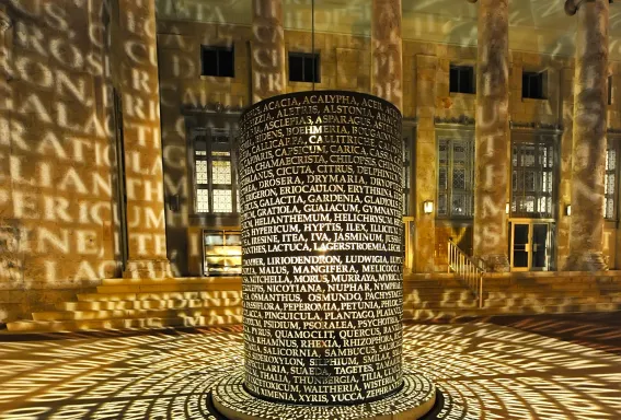 A circular light installation with projected text surrounds a central column inside the Sidney & Berne Davis Art Center in Fort Myers.