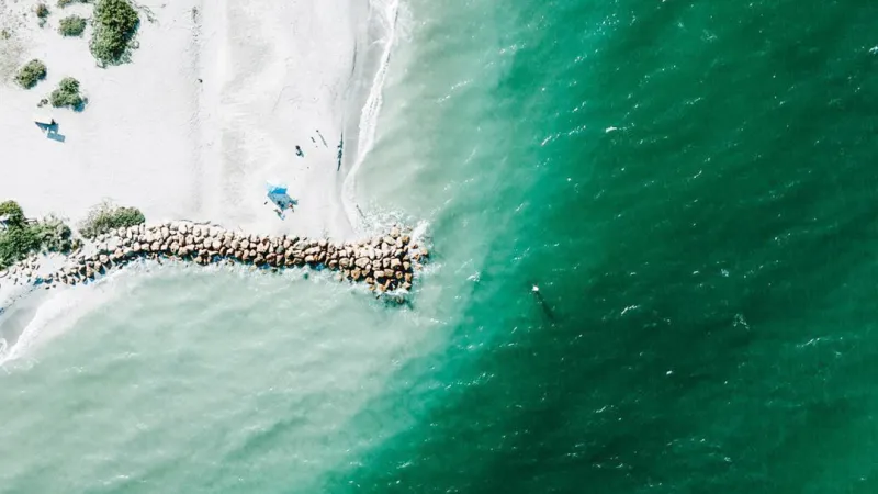 Aerial view of Blind Pass with white sand and turquoise water.