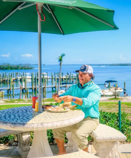 Un homme apprécie un repas à une table extérieure sur Cabbage Key