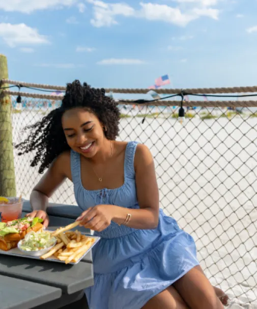 A woman dines on the beach
