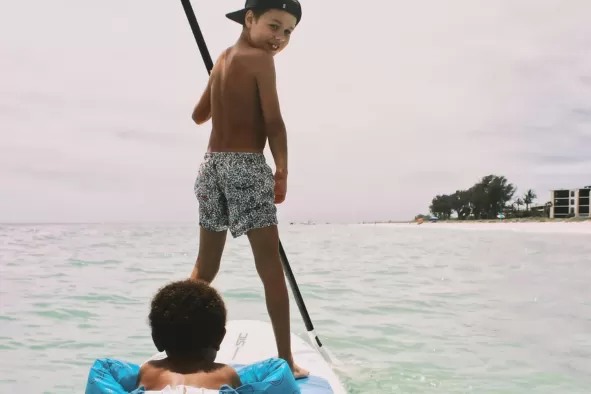 Kids enjoying paddleboarding off of Bunche Beach