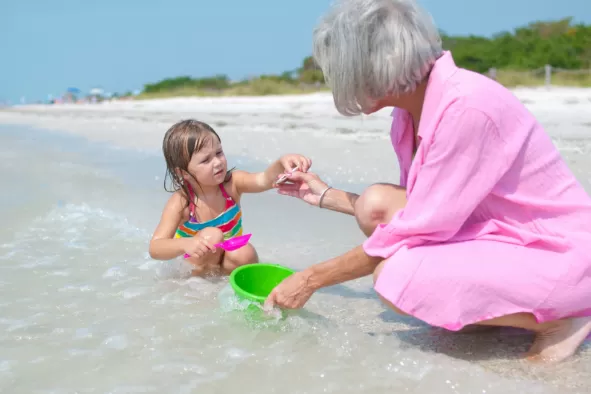 Grandma and grandchild collect seashells