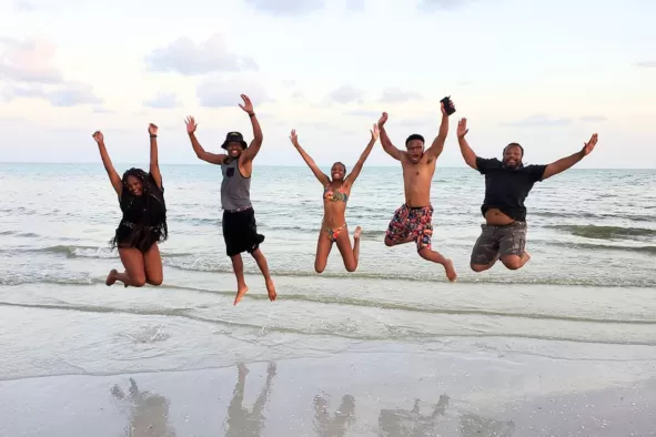 A family jumps for joy on the beach