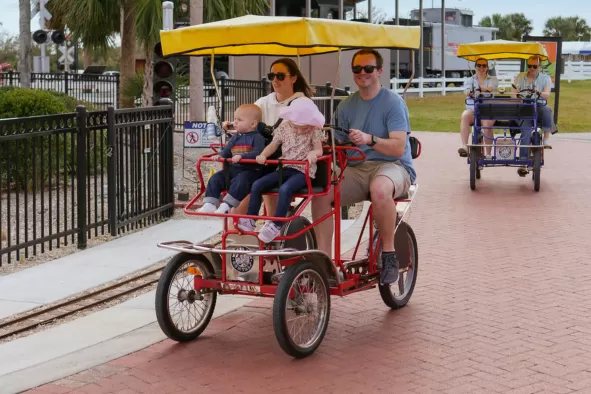 A family enjoys a bike ride at Lakes Park