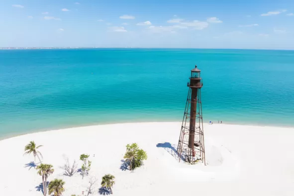 The lighthouse on Sanibel Island surrounded by pristine white sand and turquoise water